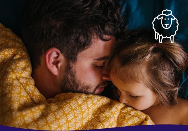 A father and daughter snuggled up asleep in bed