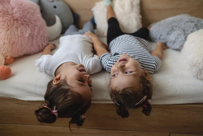 Two people carring a mattress off a Dreavery vanA woman relaxing on her bed drinking a hot drink.