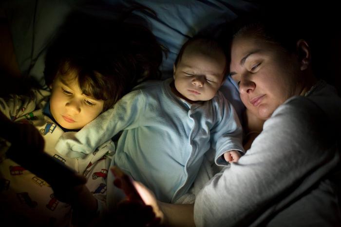 Mother sleeping in bed with baby and son