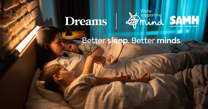 woman laying in bed reading a story to her children