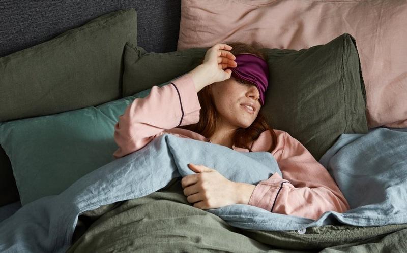 woman taking her purple sleep mask off