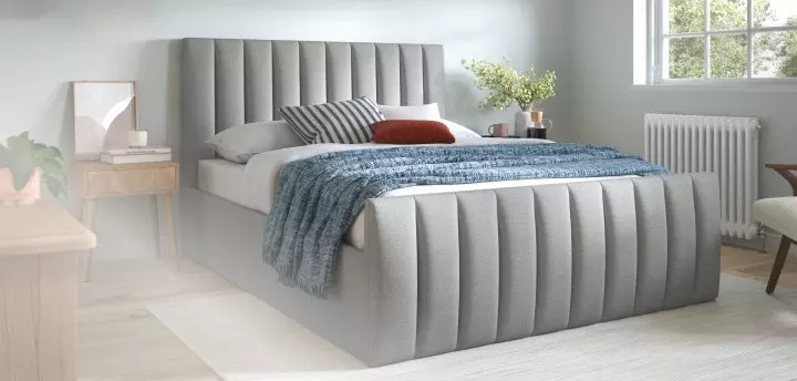 Grey divan bed in a bedroom setting.
