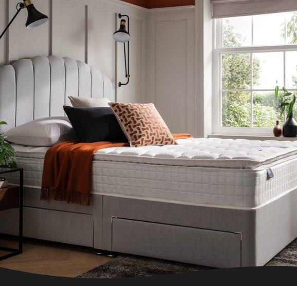 Silentnight matresses on a divan bed with cushions on it